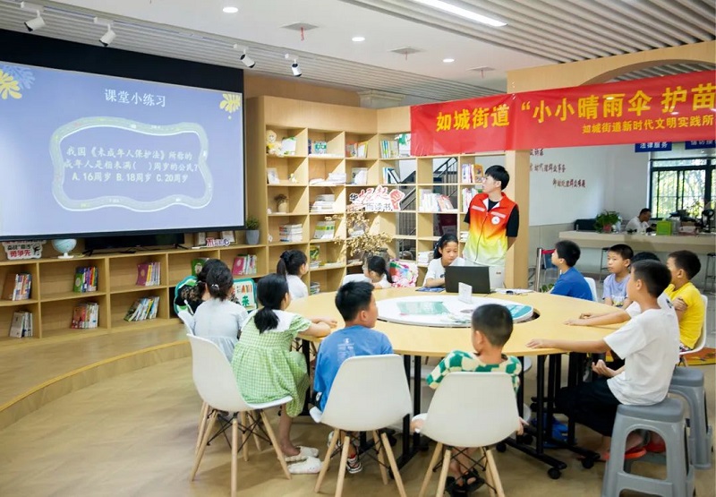 2022年8月13日，在江苏南通如皋市如城街道城西社区农家书屋内，志愿者向学生们普及《中华人民共和国未成年人保护法》法律知识。