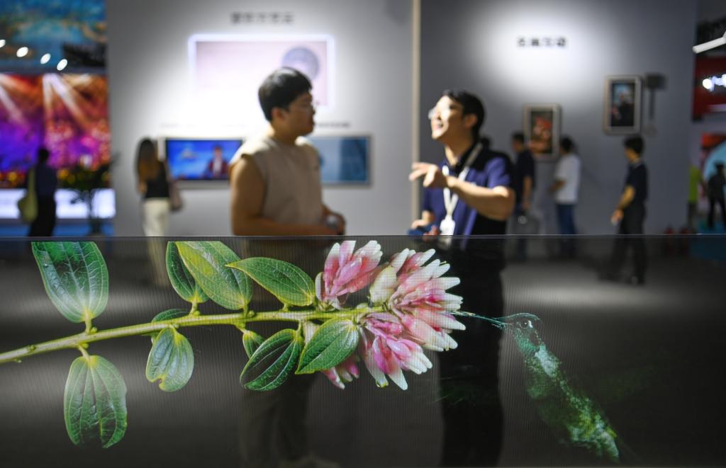 8月18日，参观者在数字文化馆了解透明OLED调光显示炫窗。新华社记者 邹竞一 摄