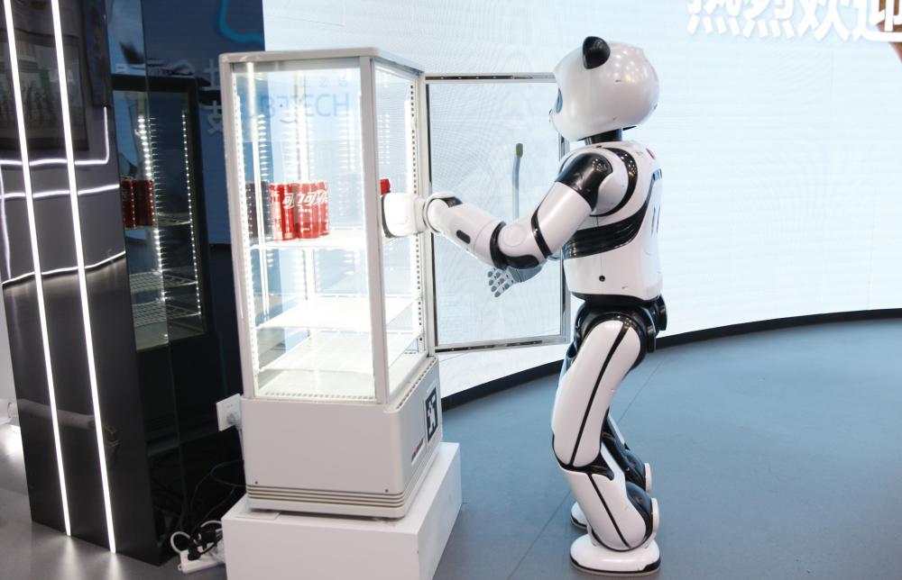 在深圳市优必选科技股份有限公司展厅内，熊猫机器人从冰柜中取出一听可乐（2024年2月29日摄）。新华社记者 洪泽华 摄