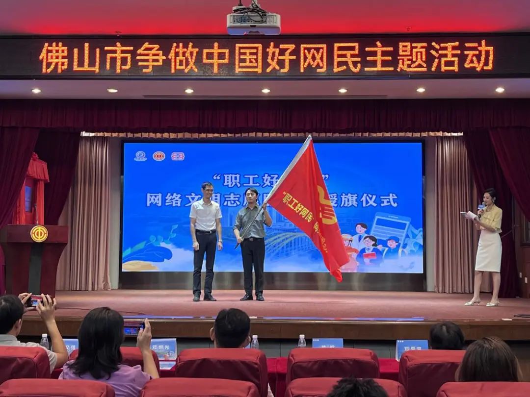 佛山市总工会宣传教育和经济工作部副部长熊昭（右）作为代表，接过网络文明志愿服务队队旗。