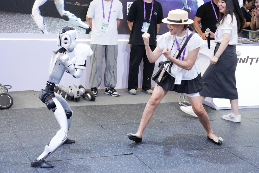 2025年9月19日，在第22届中国—东盟博览会上的人工智能专馆里，一台人形机器人表演“拳击”，与观众互动。新华社记者 周汀鹭 摄