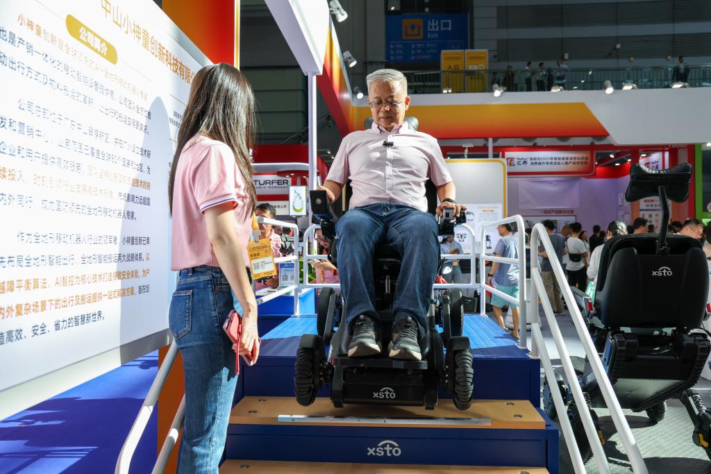 2025年9月12日，在2025深圳国际智慧养老产业博览会上，观众在展会现场体验一款可以上下楼梯的智能出行机器人。新华社记者 梁旭 摄